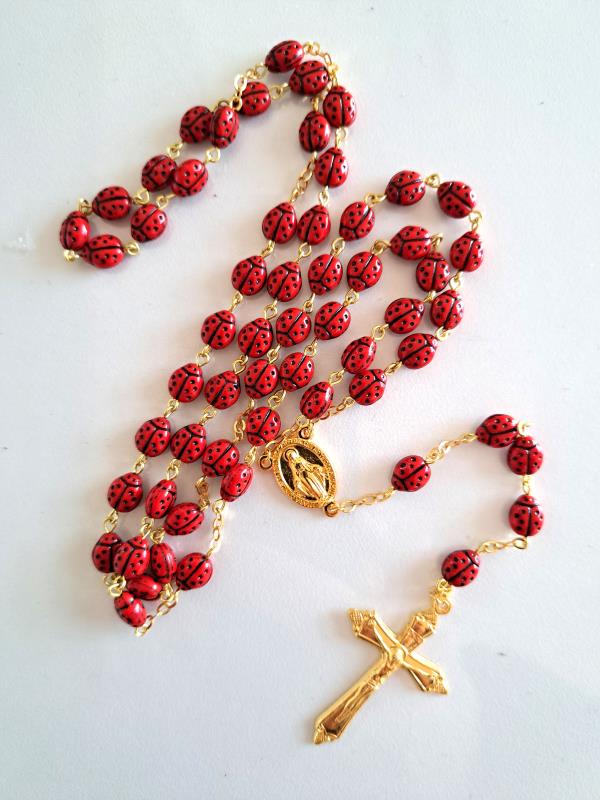 rosario in metallo dorato e grani cocinella