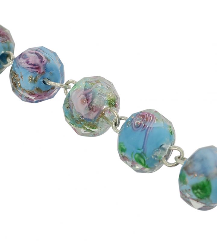 braccialetto con grani di diametro 7 mm in vetro sfaccettato di colore azzurro con fiori di colore rosa. 