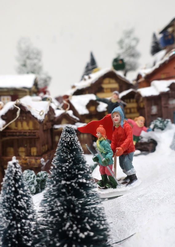 villaggio di natale su montagna, con stazione sciistica, funivia e pista da sci con sciatori, movimento, luci e musica