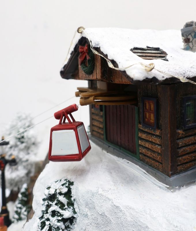 villaggio di natale su montagna, con funivia, pista da sci e pattinatori sul lago, con movimento, luci e musica